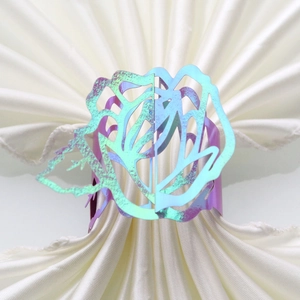 Detail of laser-cut rose napkin ring with iridescent metallic finish and hollow design