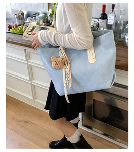 Light blue faux crocodile tote bag with teddy charm shown in a kitchen setting