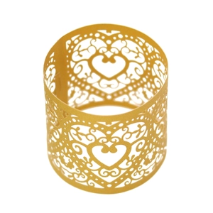 Macro detail of laser-cut gold heart napkin ring with intricate hollowed patterns