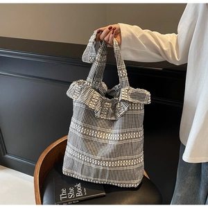 Détail du sac cabas en toile à carreaux avec bords volantés et rayure tissée blanche