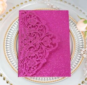 Close-up of glitter rose gold laser cut wedding invitation on decorative plate