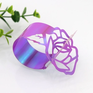 Detail view of iridescent purple laser-cut rose napkin ring with metallic luster