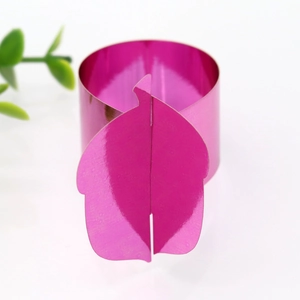 Macro detail of magenta metallic napkin ring with leaf buckle for holiday tables