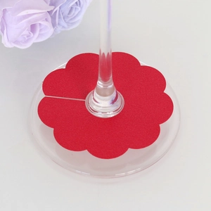 Macro detail of red petal-shaped wine glass cards for festive party table settings