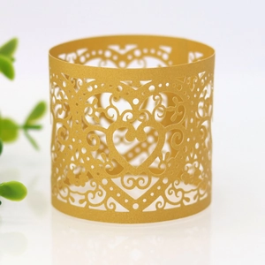 Detailed view of laser-cut gold pearlescent paper napkin ring with heart pattern