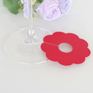Close-up of red flower paper glass markers for wine cup stem decoration and name seating