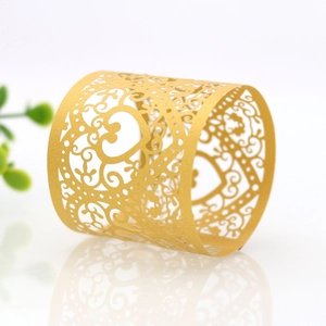 Close-up of golden laser-cut heart napkin ring with intricate hollowed patterns