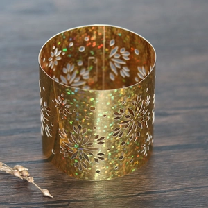 Detail of golden hollow napkin ring with laser-cut snowflakes and holographic glitter effect