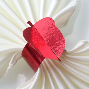 Metallic red apple-shaped napkin rings on white silk napkins for Thanksgiving decor
