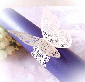 Close-up of laser-cut ivory butterfly napkin ring with intricate lace texture details