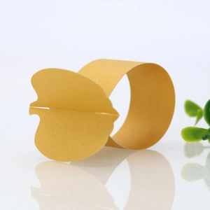 Detail of golden butterfly hollow paper napkin ring for elegant wedding table settings