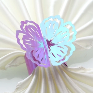 Macro detail of laser-cut butterfly napkin ring with iridescent purple-blue gradient finish