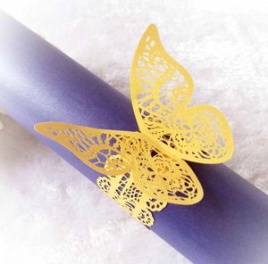 Macro detail of laser-cut golden lace butterfly napkin ring on a purple roll