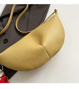 Detail of lemon yellow crescent shoulder bag with lychee grain leather and red heart charm