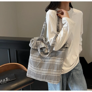 Détail du sac cabas en toile à carreaux noir et blanc avec bords volantés élégants
