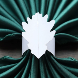 Détail d'un rond de serviette en papier blanc avec design de feuille élégant et ajouré
