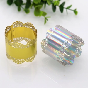Close-up of laser-cut lace napkin rings in shimmering gold and holographic silver finishes