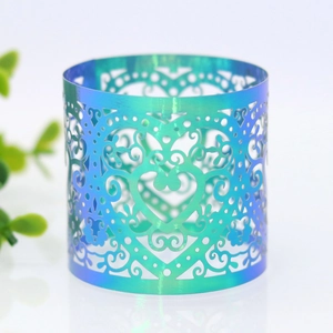 Macro detail of laser-cut heart pattern on iridescent blue-green napkin ring