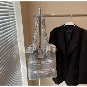 Détail d'un sac cabas en toile vichy noir et blanc avec des bords à volants délicats