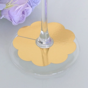 Close-up of golden flower-shaped wine glass stem markers for party table settings
