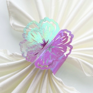 Macro detail of laser-cut floral napkin ring with iridescent metallic shimmering finish