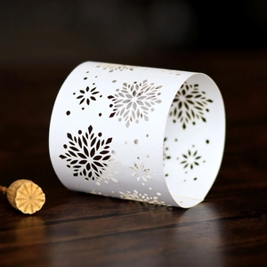 Close-up of white laser-cut snowflake napkin ring with hollow patterns for Christmas
