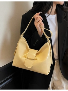Minimalist beige dumpling shoulder bag with gold crescent metal detail for women