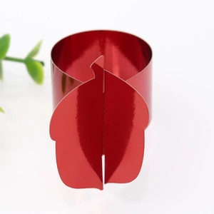 Detail of red metallic finish paper napkin ring with leaf design for festive table settings