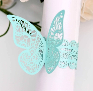 Detail of laser-cut butterfly napkin ring in mint green with intricate hollow patterns