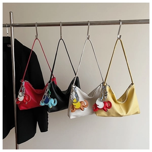 Detail of four colorful pebbled leather hobo bags with elephant charms in a stylish row