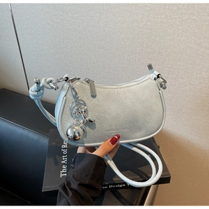 Detail of light blue crescent bag featuring pleated texture and silver balloon dog charm