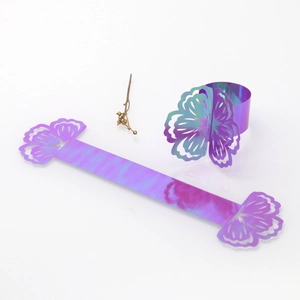 Iridescent purple laser cut paper napkin ring with hollow floral detail on white background