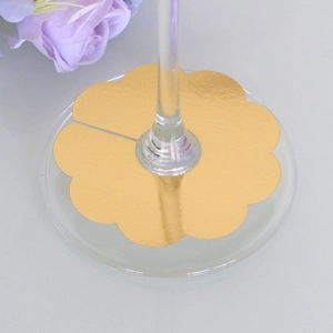 Detail of gold petal-shaped wine glass marker made of metallic foil paper for parties