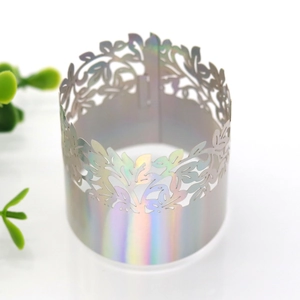 Detailed laser-cut holographic golden napkin ring with intricate vine leaf pattern