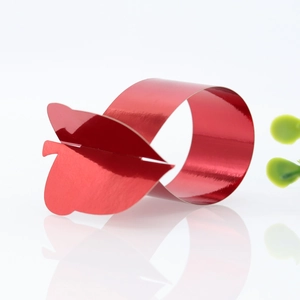 Detail of red metallic butterfly napkin ring with glossy finish for festive table decor