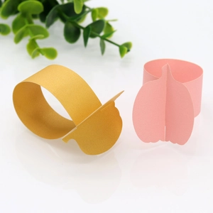 Detail of gold and pink pumpkin paper napkin rings with shimmering pearlescent finish