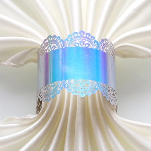 Close-up of holographic purple laser-cut napkin ring with delicate lace pattern