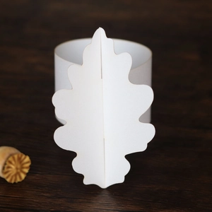 Vue rapprochée d'un rond de serviette en papier blanc 3D en forme de feuille sur bois