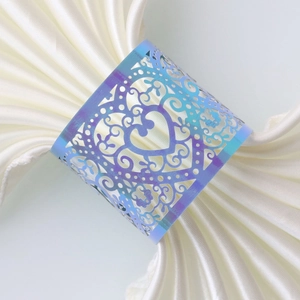Macro view of blue-purple laser-cut heart napkin ring with intricate floral patterns