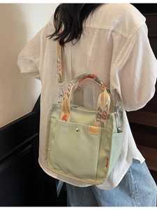 Mint green canvas tote bag with floral pattern straps shown from a side angle