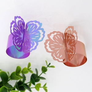 Detail of laser-cut butterfly napkin rings in rose gold and iridescent laser finish