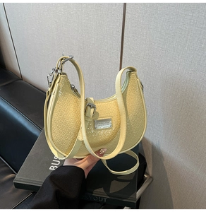 Detail of light yellow hobo bag showing crocodile texture and silver metal buckle