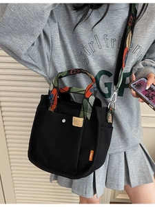 Large black canvas tote bag with colorful floral straps and crossbody shoulder strap