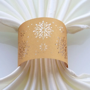 Close-up of golden glitter laser-cut snowflake paper napkin ring for holiday decor