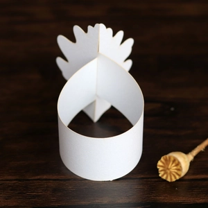 Gros plan détaillé d'une couronne en papier blanc pour les fêtes sur fond de bois