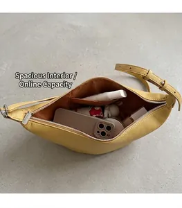 Spacious interior of the yellow leather croissant bag showing daily essentials and lining