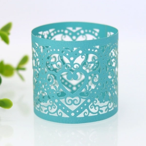 Macro shot of light blue laser-cut heart pattern cupcake wrapper for wedding decor