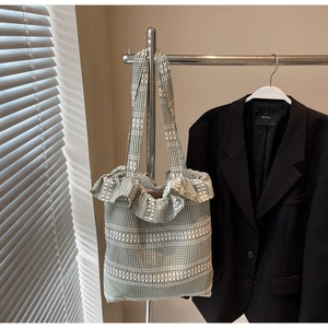 Détail d'un sac cabas en toile vichy vert et blanc avec bords volantés et bandoulière