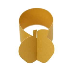 Detail of golden apple-shaped pearlescent paper napkin ring for festive table decoration