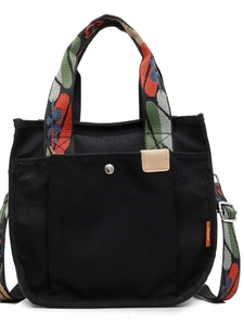 Large black canvas tote bag with floral print handles and front button pocket